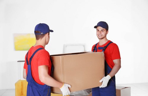 Movers handling office furniture and IT items during a local relocation