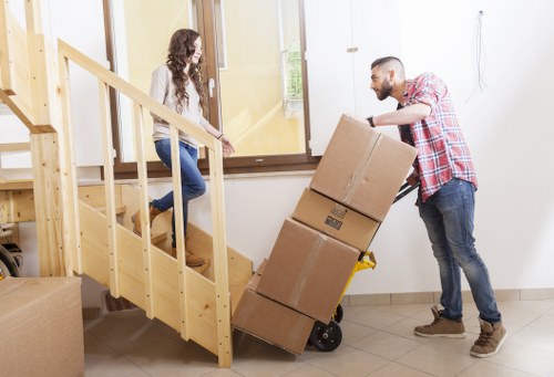 Professional movers handling stairs in a Queens Park flat